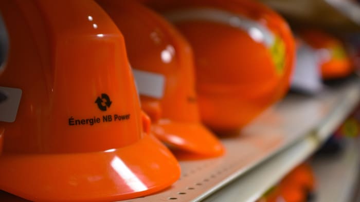 Des casques de travailleurs d'Énergie NB sur une tablette.