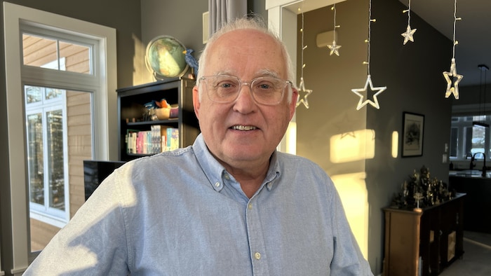 Yves Gagnon est debout dans un salon. Il sourit.