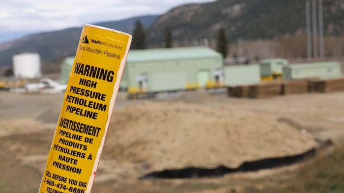 Un piquet jaune mentionne la présence du pipeline sous terre.