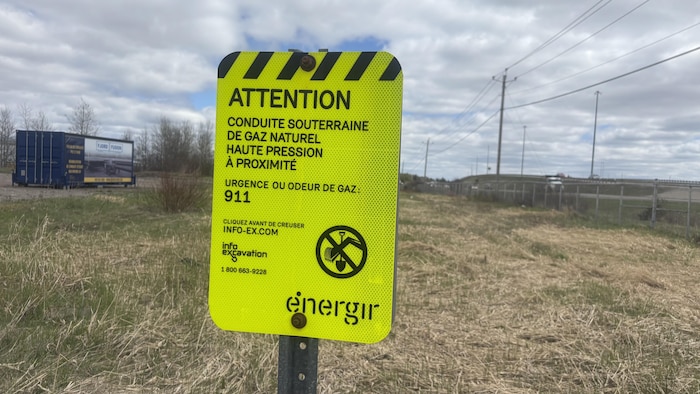 Une pancarte jaune dans un terrain vague.