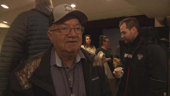 Un homme souriant, portant une casquette 