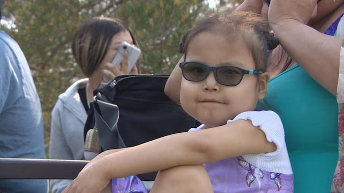 Portrait d'une petite fille de 6 ans portant des lunettes de soleil.