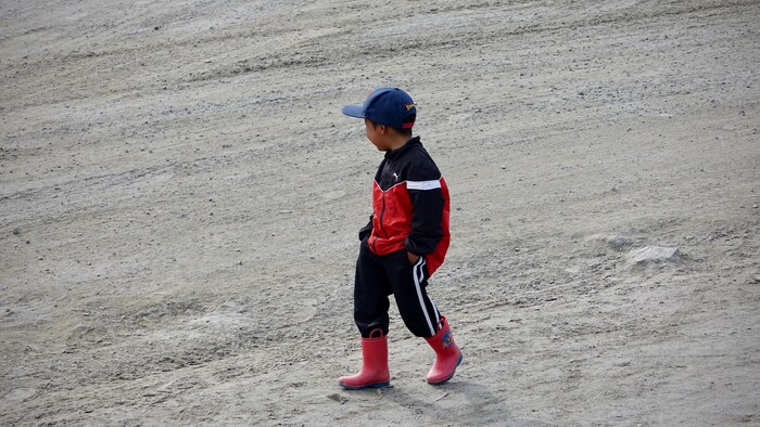 Un enfant marche dans une rue de Clyde River, une communauté de l'île de Baffin, au Nunavut.