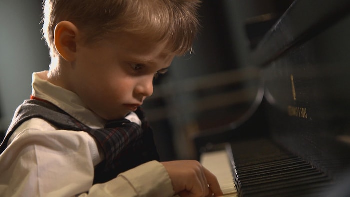 Un enfant joue du piano.