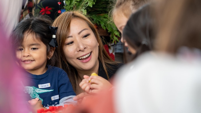 Katrina Chen est entourée d'enfants s'amusant.