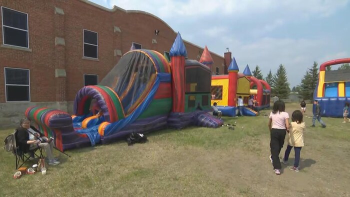 Des enfants s'amusent en plein air, dans une aire de jeux.