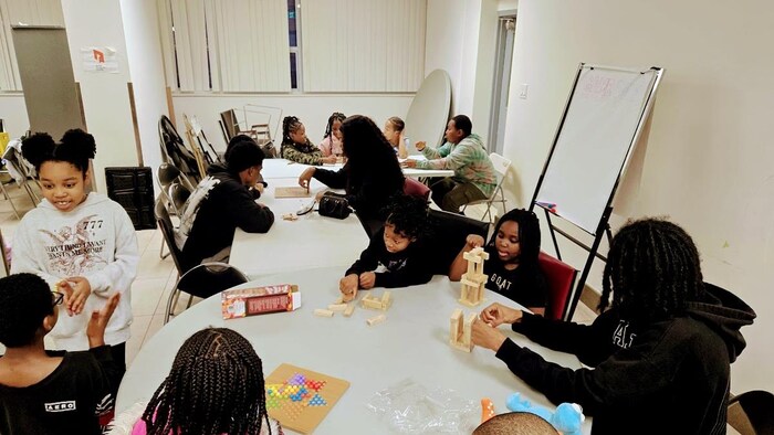Des enfants jouant ensemble autour de tables.