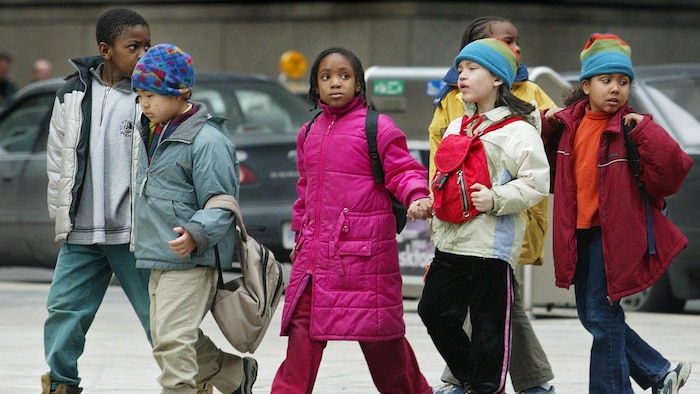 أطفال من خلفيات عرقية متعددة يمشون في الشارع.