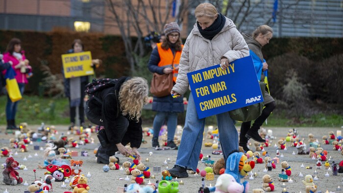 Des gens ont déposé des ours en peluche et des jouets sur le sol pour symboliser l'enlèvement d'enfants pendant la guerre en Ukraine, lors d’un événement organisé par l’ONG Avaaz et des réfugiés ukrainiens au rond-point Schuman, à Bruxelles, le 23 février 2023, afin de marquer le premier anniversaire de l’invasion de l’Ukraine par la Russie. 