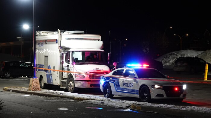 Deux véhicules de la police stationnés la nuit.