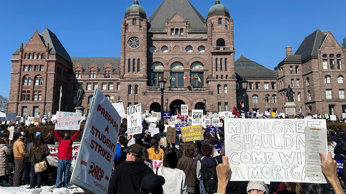 Des personnes participent à un rassemblement contre les coupes dans le RAFEO devant Queen’s Park, à Toronto, le mercredi 4 mars 2026.