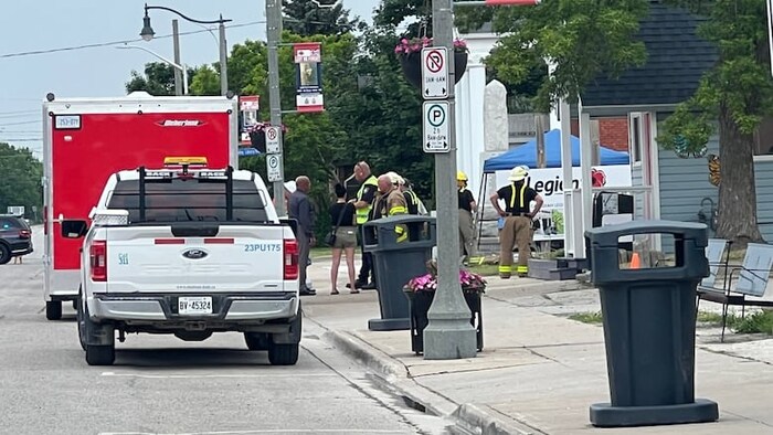 Un groupe de pompiers debout en bordure d'une route