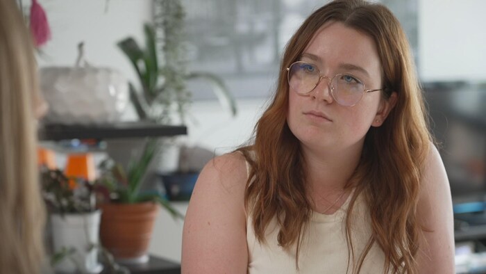 Une jeune femme écoute une autre collègue parler.
