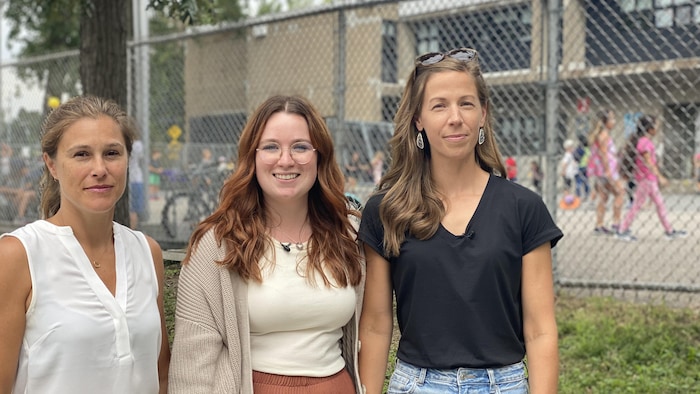 Trois étudiantes posent devant une cour d'école à Montréal