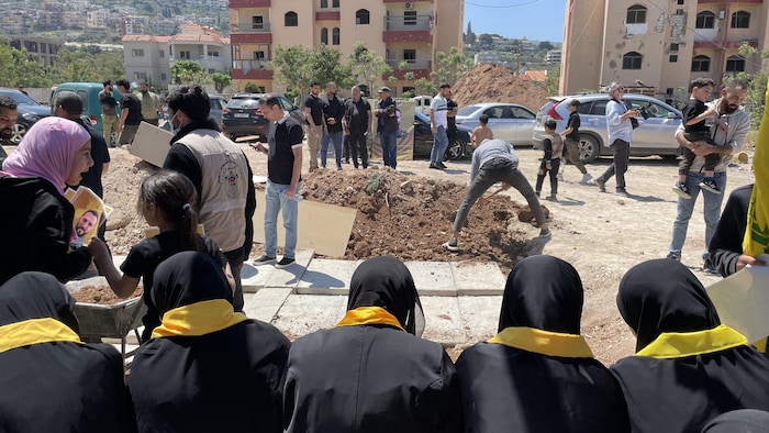 Des femmes assises lors de l'enterrement de combattants du Hezbollah dans le sud du Liban.