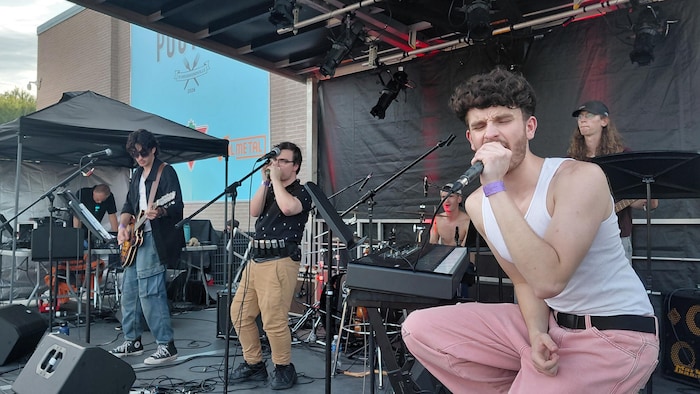 Cinq musiciens performent sur scène.