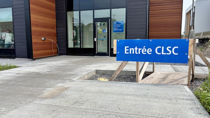 Une afffiche devant un édifice précise l'endroit pour entrer dans les locaux d'un CLSC