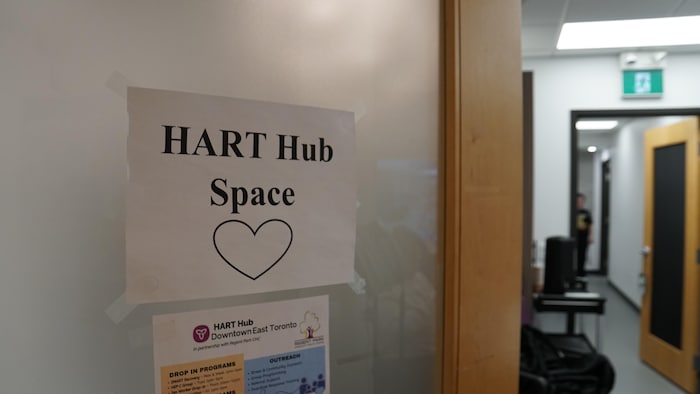 Une enseigne en papier avec les mots « HART Hub Space » sur une porte givrée.