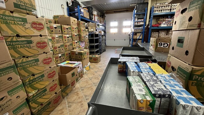 Une pièce débordant de boîtes de cartons contenant des denrées.