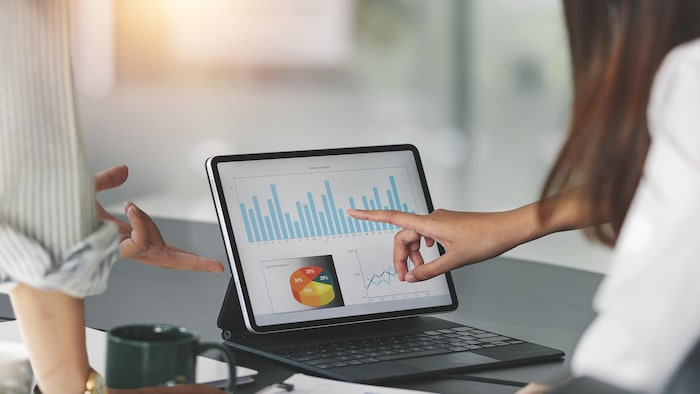 Gens d'affaires qui travaillent au bureau avec une tablette et qui fait de la planification en analysant un rapport financier.
