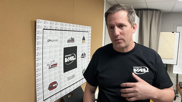 Sébastien Dufour parle dans son bureau devant une affiche.
