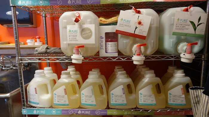 On voit des produits d'entretien ménager sur une étagère. 