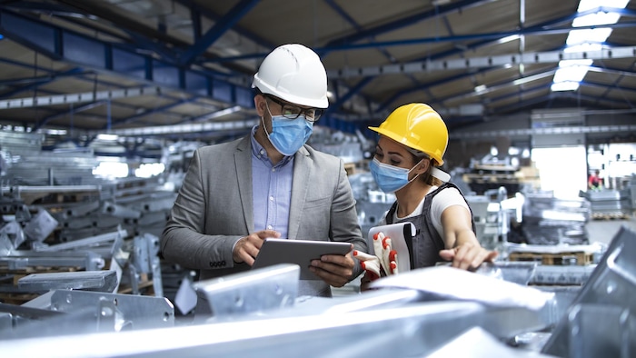 Un patron parle avec son employée dans une usine.