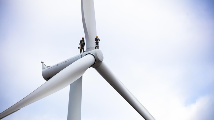 A wind turbine with two employees.