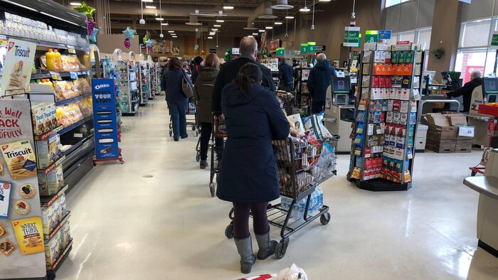Des clients font la file dans une épicerie de Charlottetown le 7 janvier 2021.