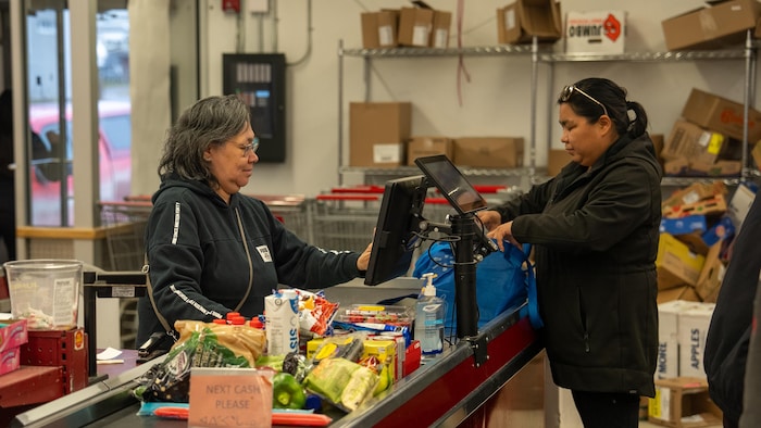 Une dame à la caisse de l'épicerie.