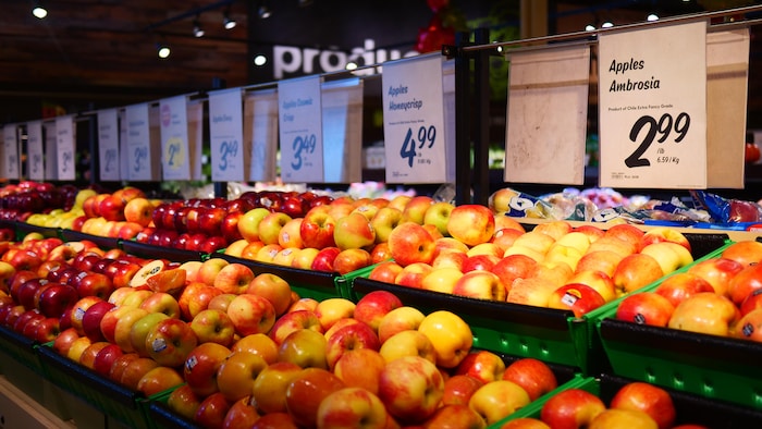 Un présentoir de pommes dans un supermarché.