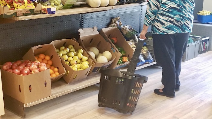 Une dame à l'épicerie sociale de Moisson Kamouraska choisit ses produits.