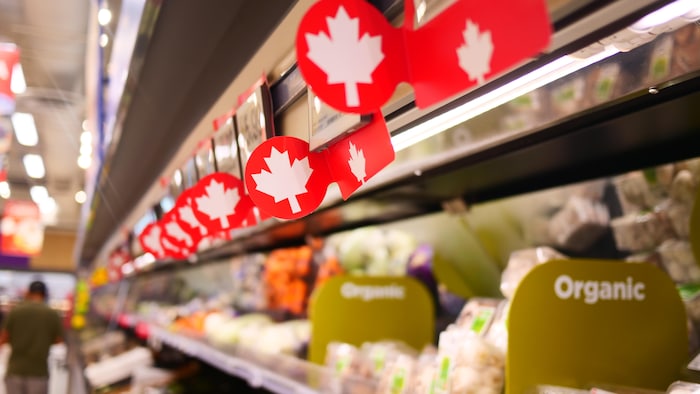 Des affichages annonçant des produits canadiens et biologiques dans une épicerie de Saskatoon, en Saskatchewan, le 15 septembre 2025.