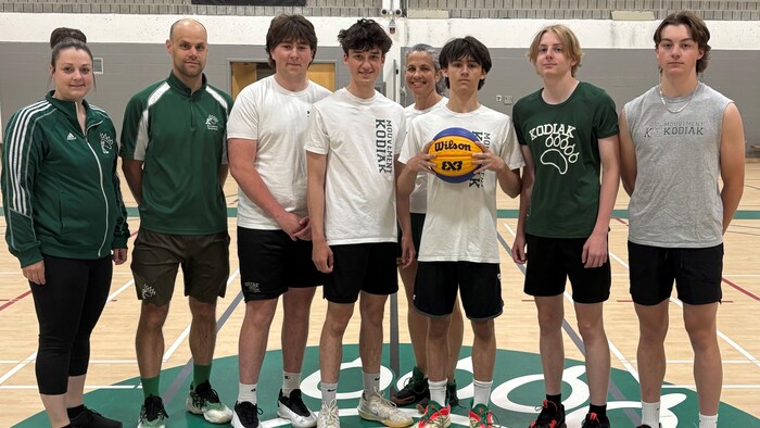 Les membres d'une équipe de basketball se mettent en ligne pour la photo.