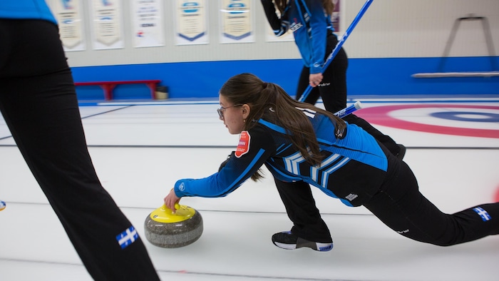 Une jeune curleuse sur la glace.