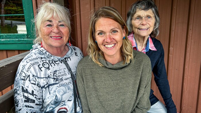 trois femmes sourient.