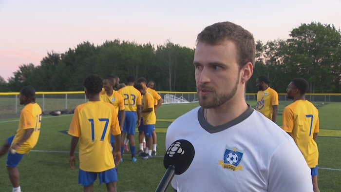 André LeBlanc sur le terrain, entouré de joueurs.