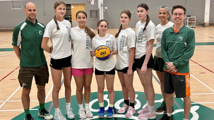 Les membres d'une équipe de basketball se mettent en ligne pour la photo.
