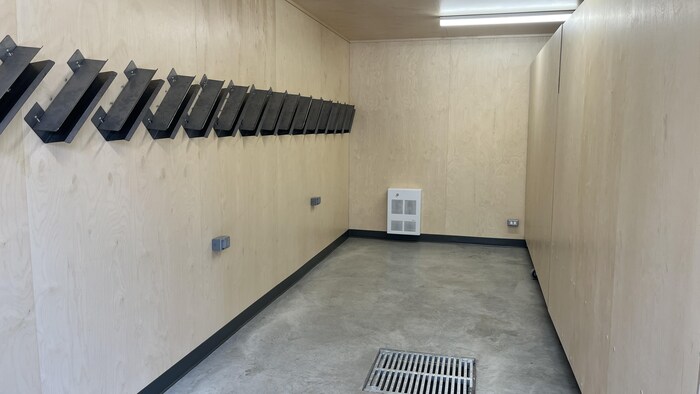 Salle vide avec des supports au mur qui pourront accueillir de l'équipement.