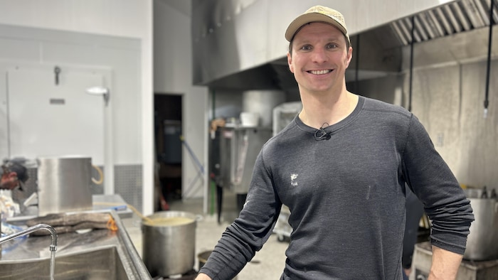 Antoine Roussel, souriant, dans les locaux de production du beurre d'érable.