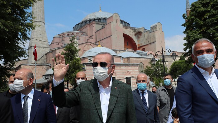 Recep Tayyip Erdogan, masqué, salue la foule devant l'ex-basilique.