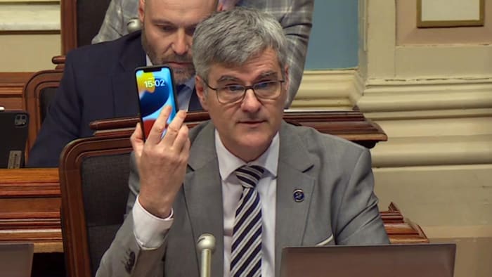 Éric Caire brandit un téléphone cellulaire lors de l’étude des crédits budgétaires à l’Assemblée nationale.