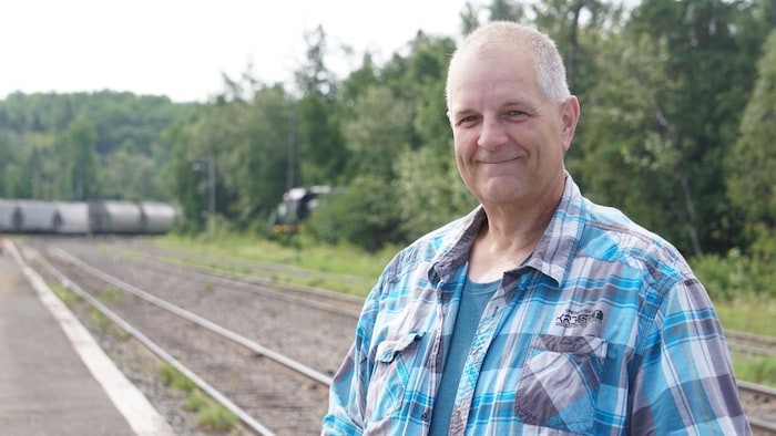 Éric Dubé, photographié en bordure du chemin de fer.