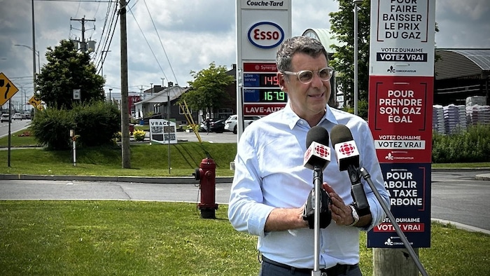 Éric Duhaime en constituent   de presse devant une station-service.