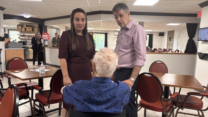 Éric Duhaime et sa candidate Patricia Drouin discutent avec une personne âgée. 