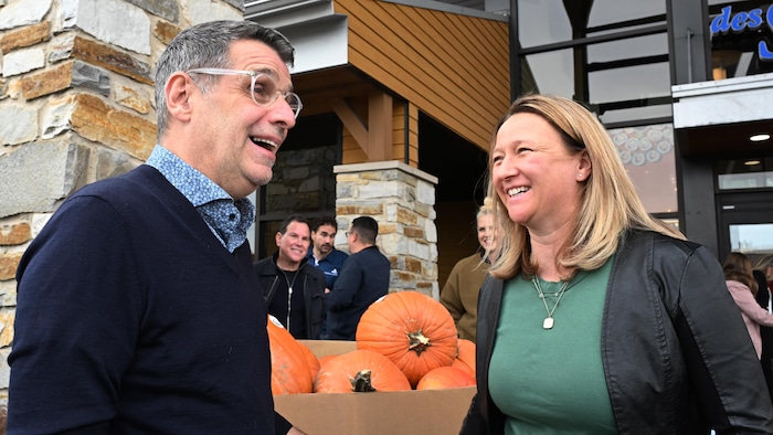Éric Duhaime et Maïté Blanchette Vézina rien à côté d'un étalage de citrouilles.