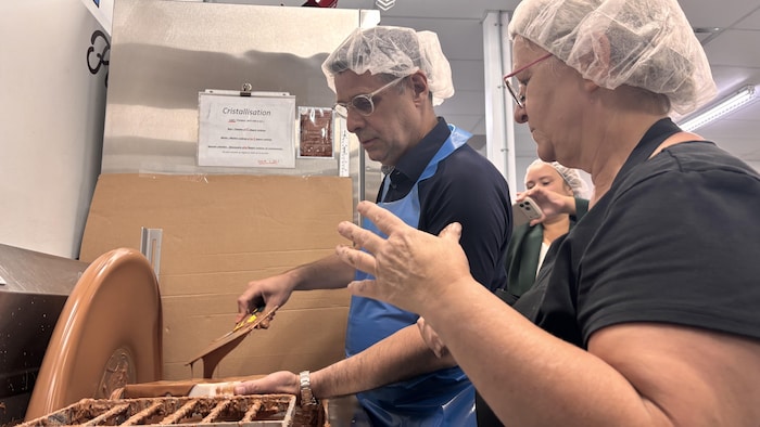 Éric Duhaime fait du chocolat avec un bonnet sur la tête.