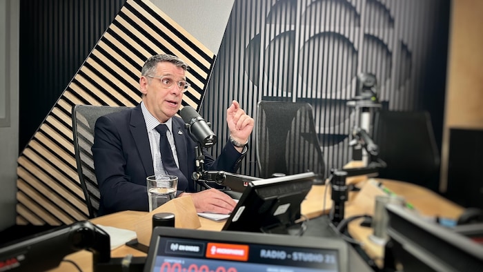 Éric Duhaime assis en studio.