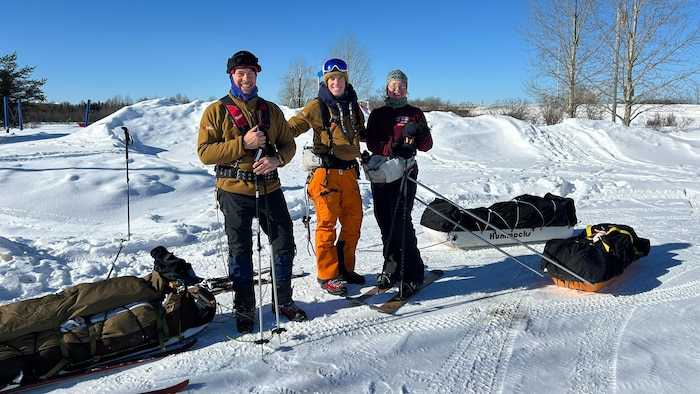 Éric Dupras, Marine Claracq et Véronique Samuel-Thomassin sont sur leur ski de fond, près des traîneaux avec leur matériel.