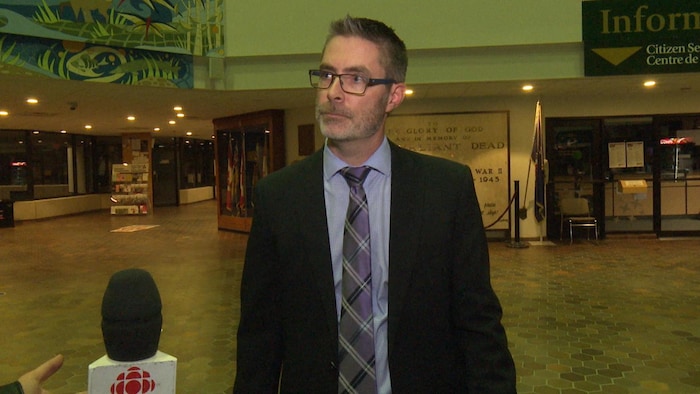 Eric Labelle se tient debout dans le hall d'entrée de la mairie de Sudbury.
